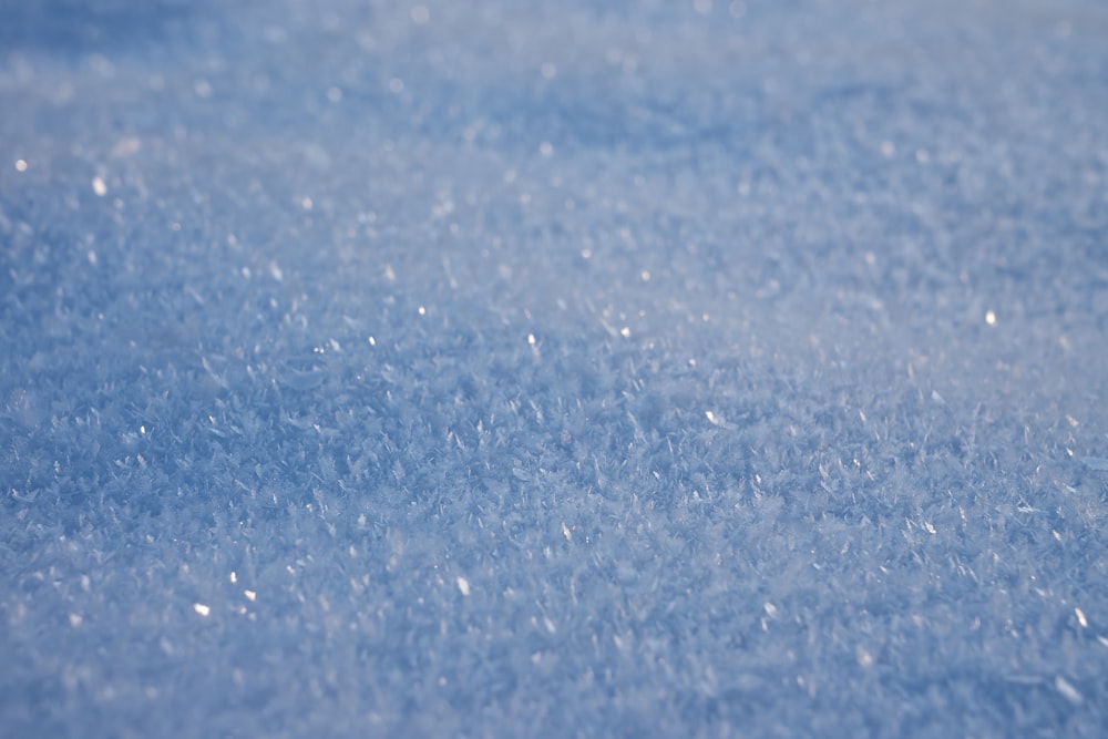 a close up of a blue surface with snow flakes