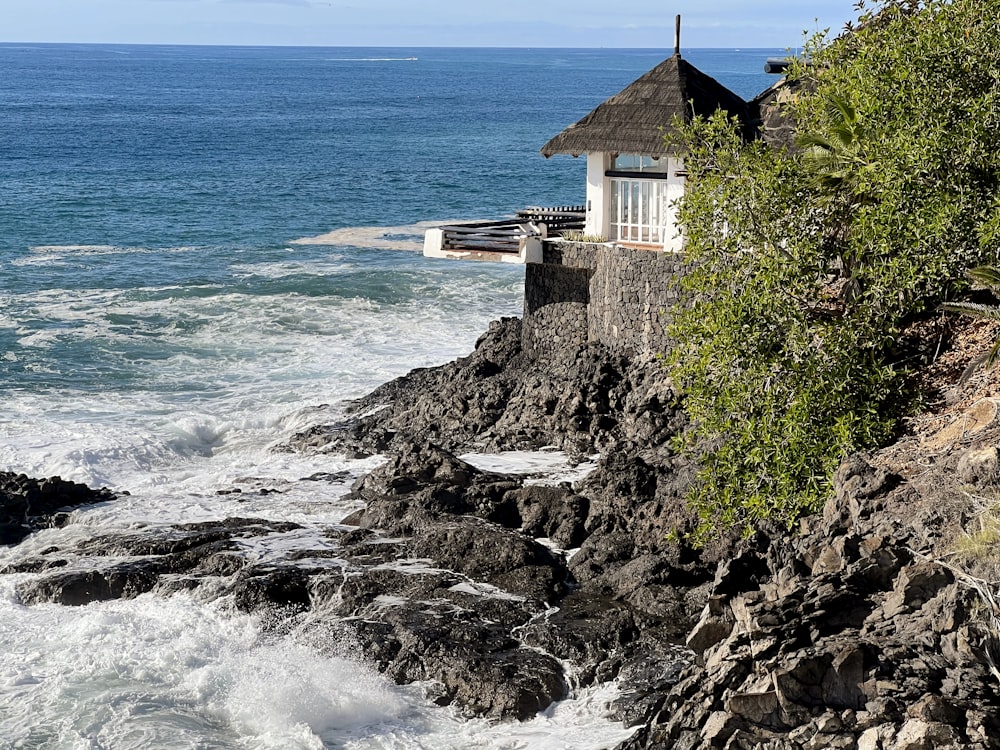 Una casa seduta sulla cima di una scogliera vicino all'oceano