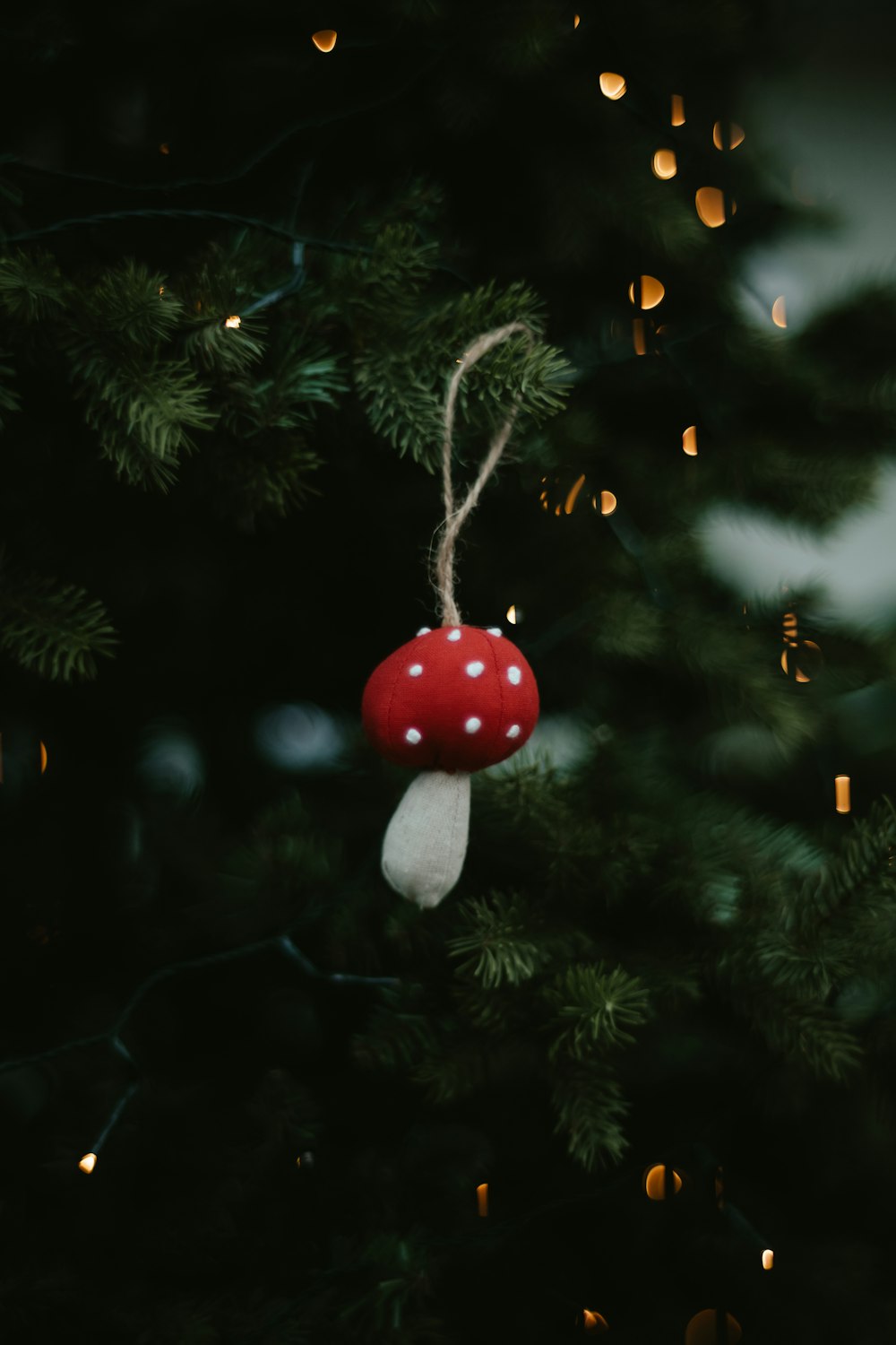 a mushroom ornament hanging from a christmas tree