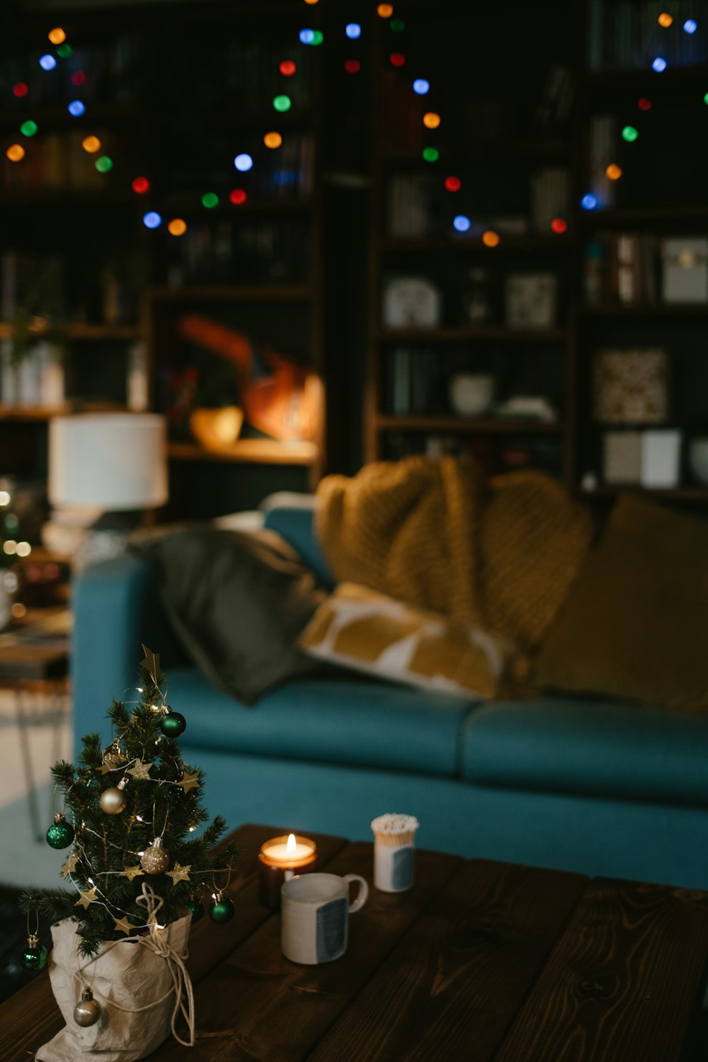 a living room with a blue couch and a christmas tree