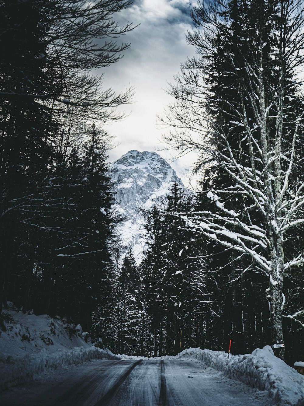 a snow covered road with a mountain in the background