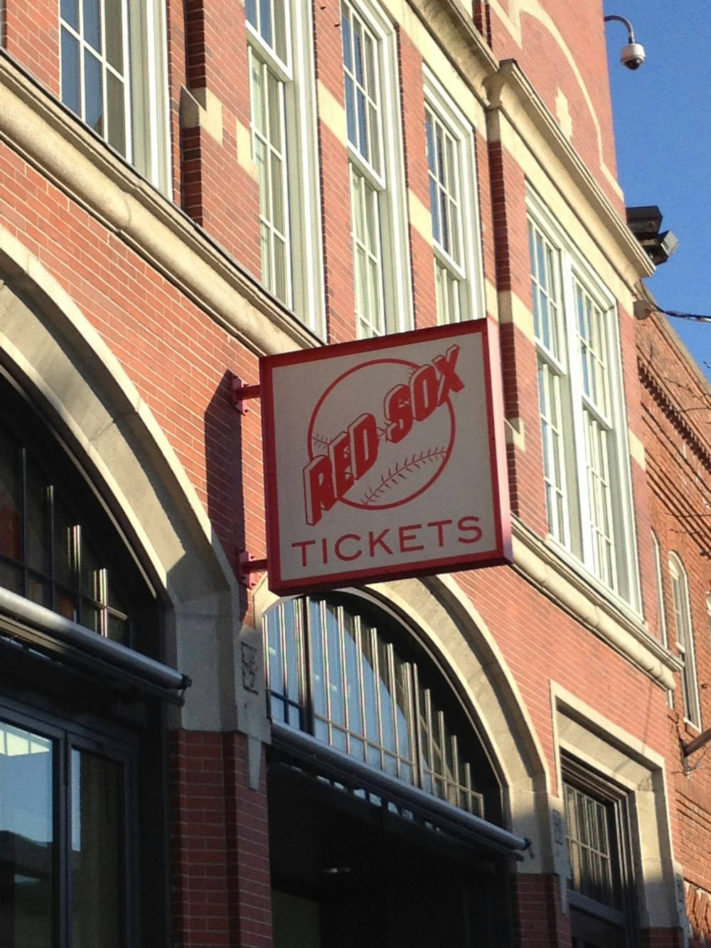 a red sox sign hanging from the side of a building