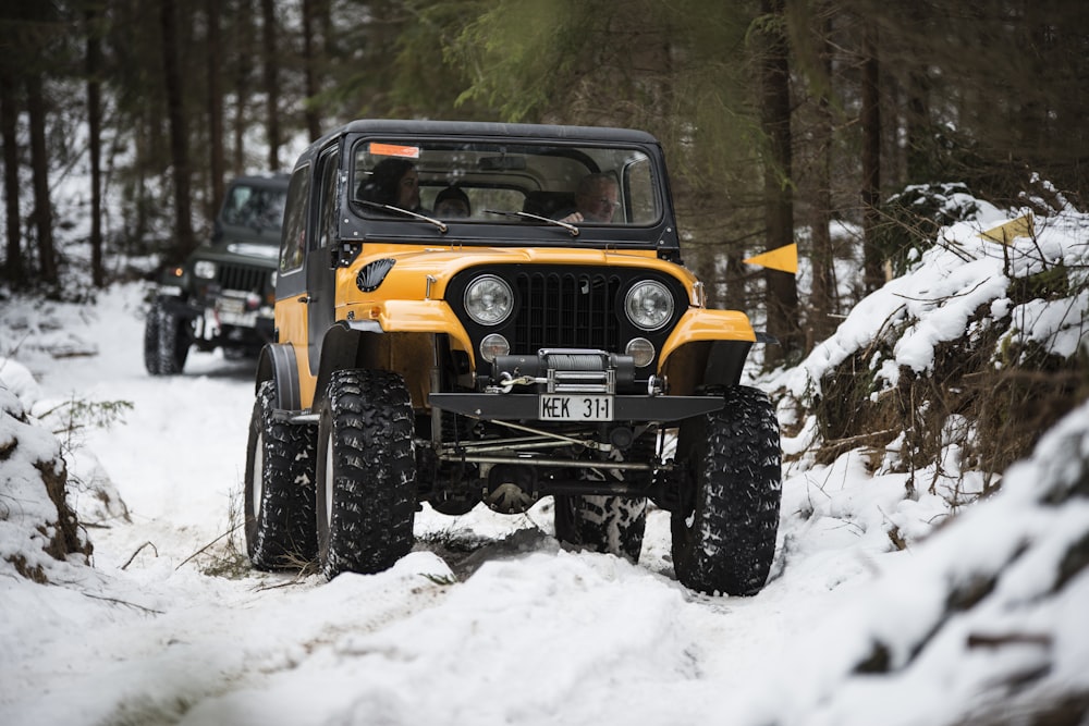 a jeep driving through the snow in the woods