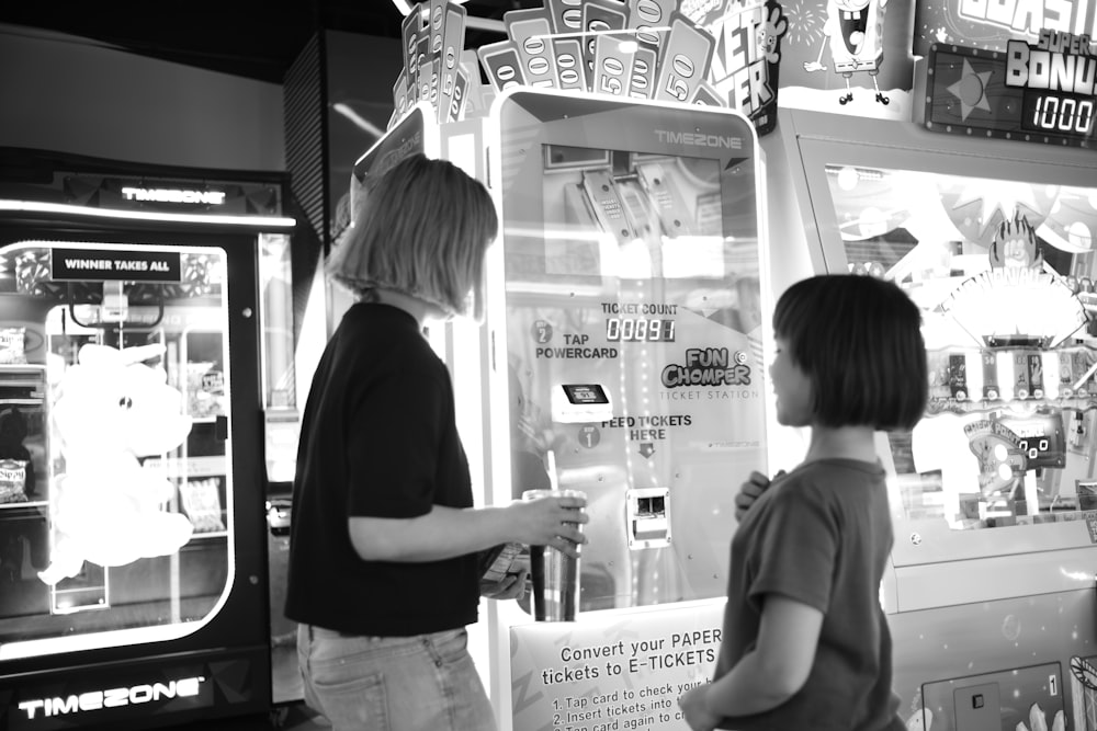 two people standing in front of a vending machine