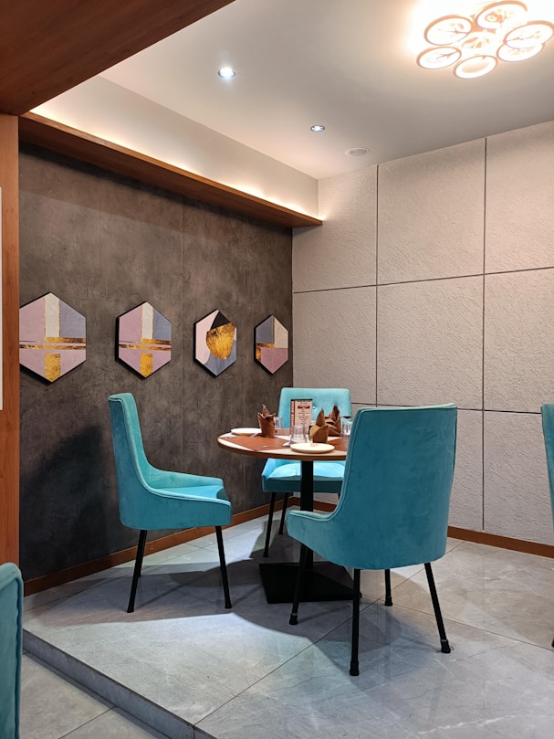 a dining room with blue chairs and a round table