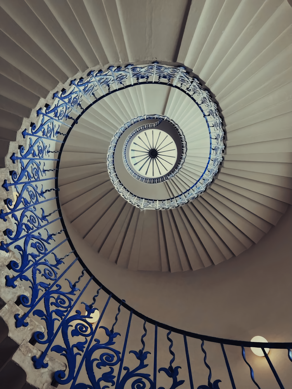 a spiral staircase in a building with blue railings