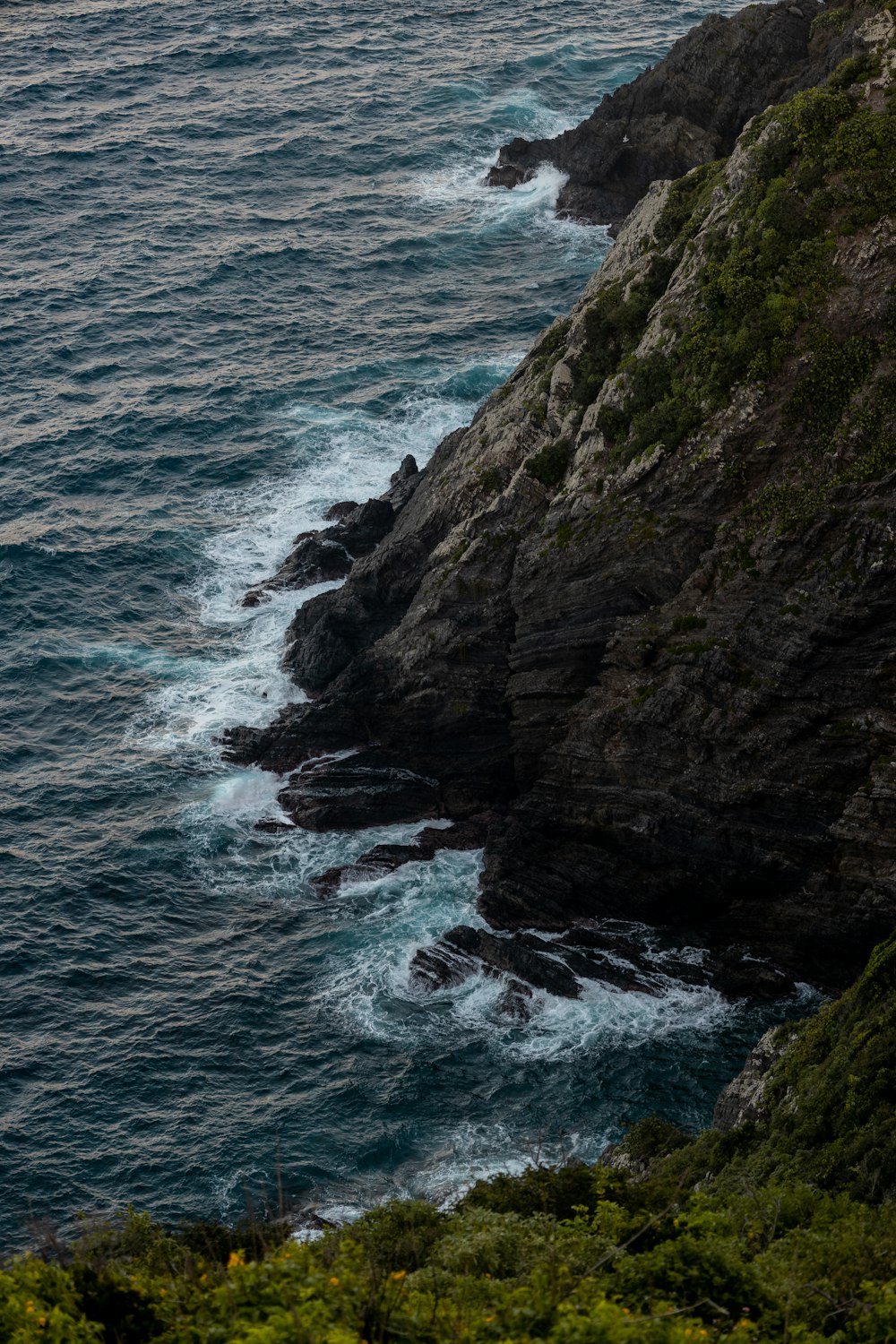 a large body of water next to a rocky cliff