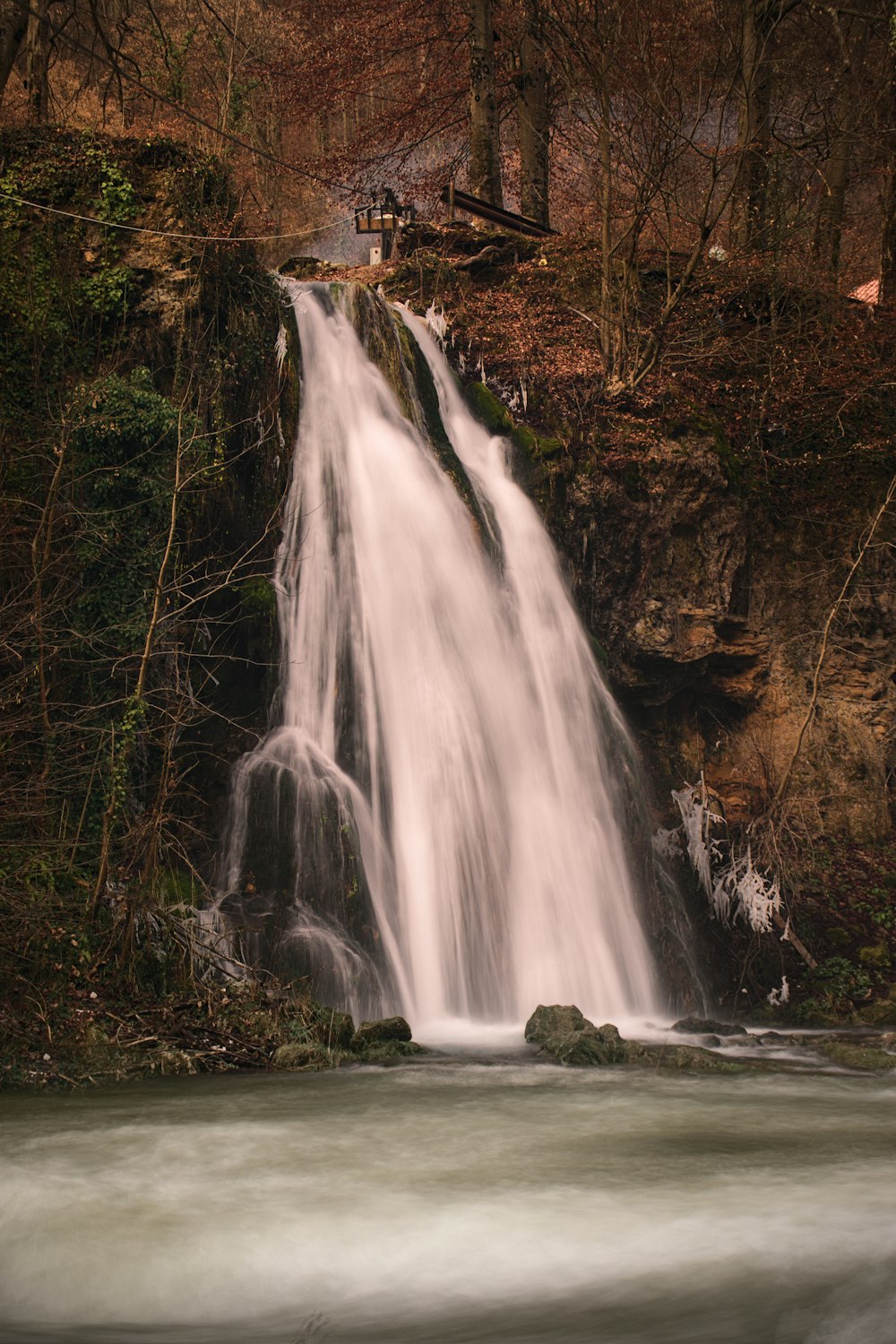 a waterfall in a wooded area with trees