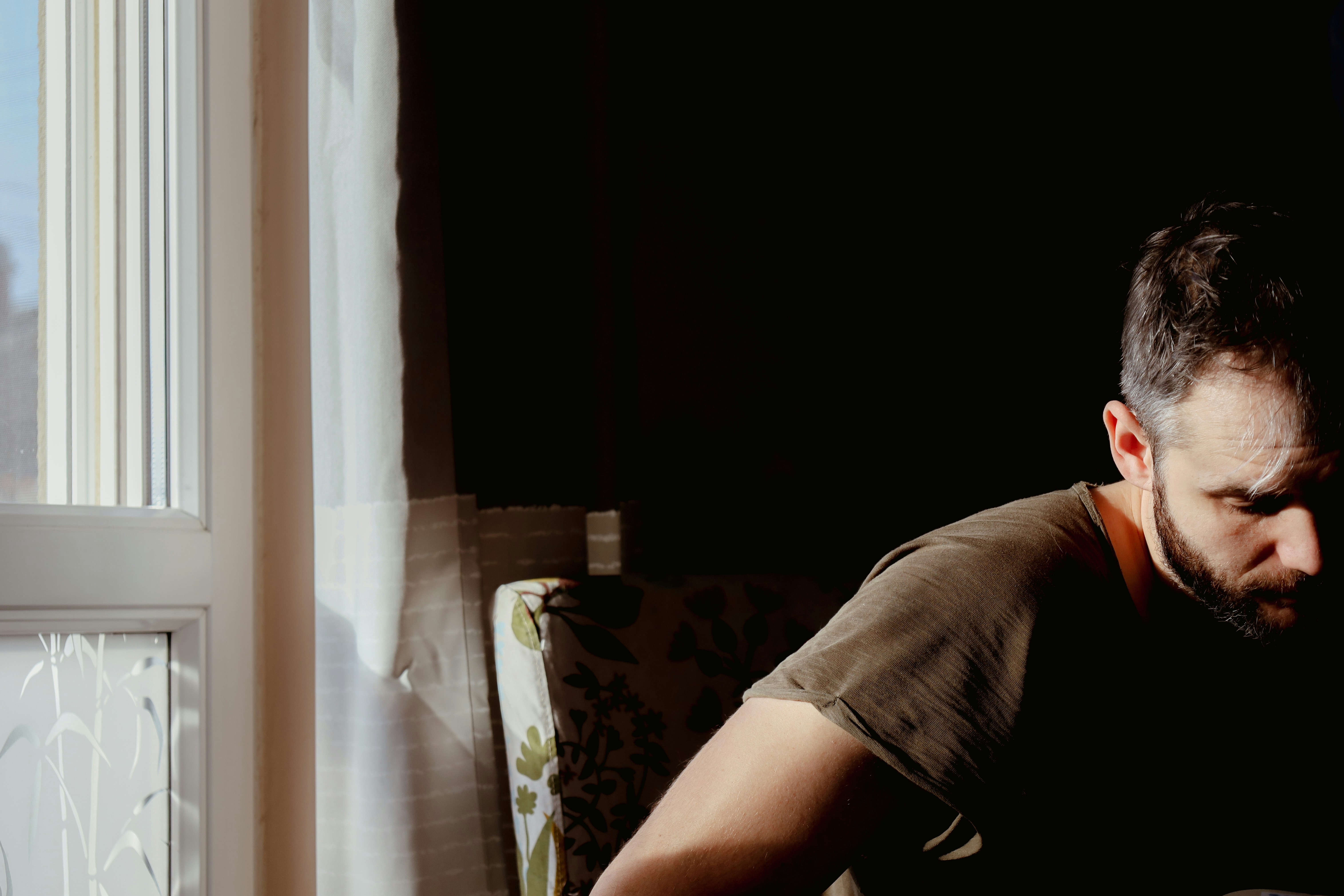 a man sitting in a chair looking at a laptop