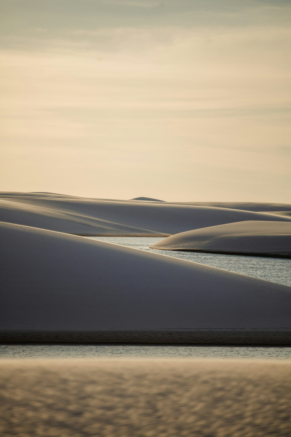 a body of water surrounded by sand dunes