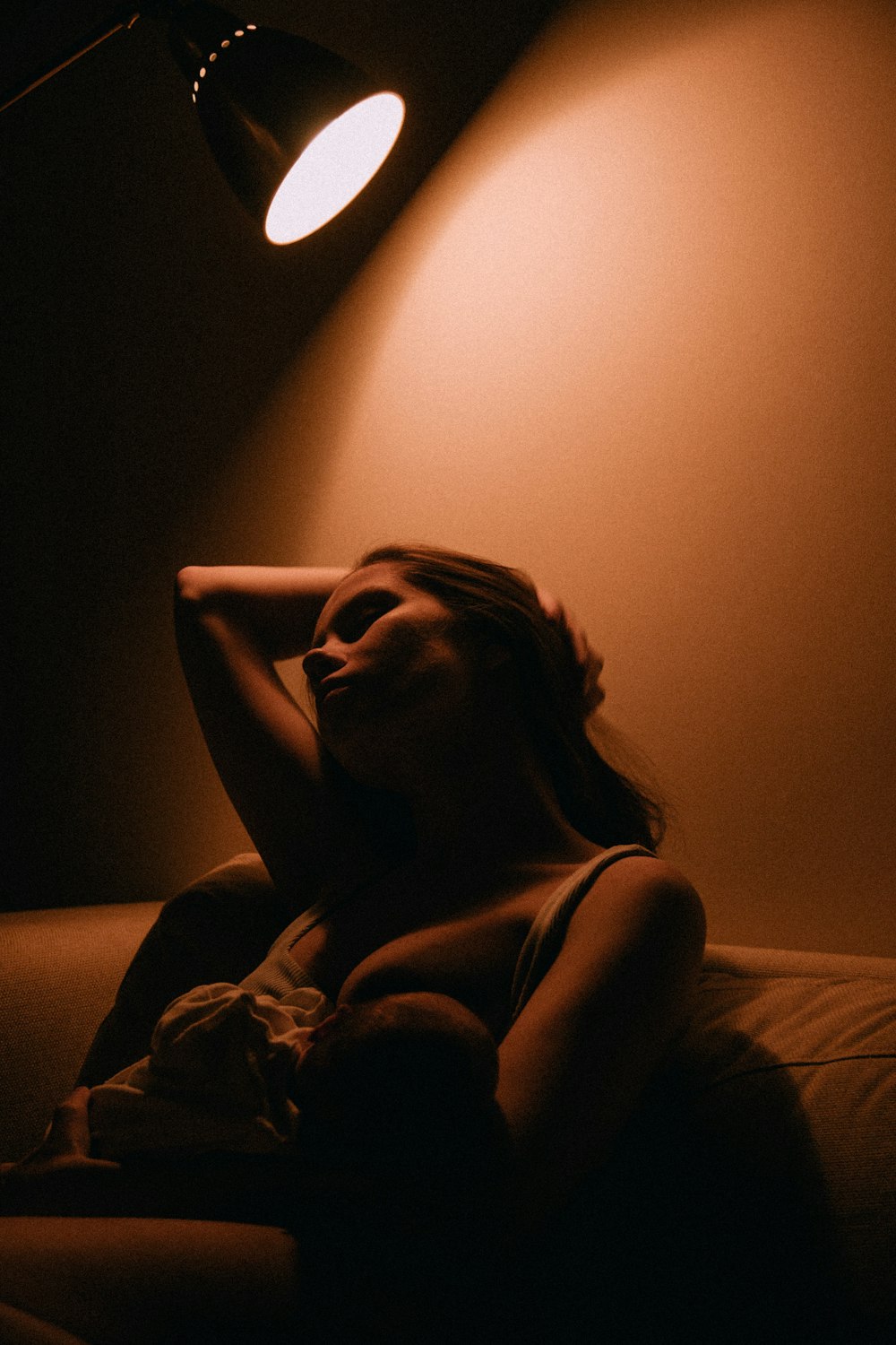 a woman sitting on a couch in a dimly lit room