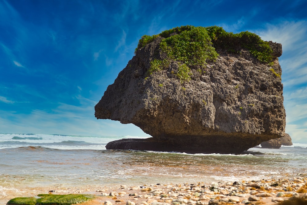 a large rock sitting on top of a sandy beach