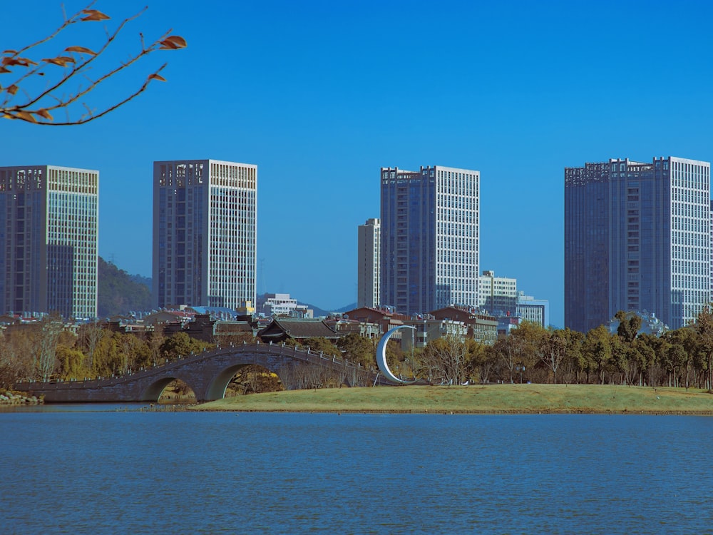 a bridge over a body of water with tall buildings in the background
