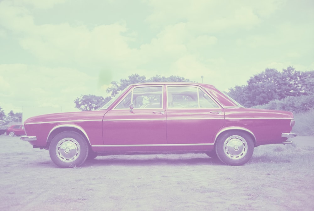 a pink car parked in a parking lot