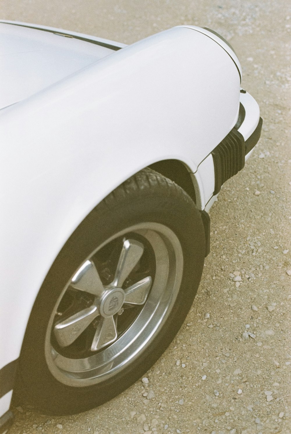 a close up of a white car on a street