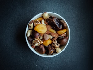 a white bowl filled with nuts on top of a table