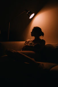 A calm person attentively listening in a cozy, dimly lit room with blue accents.