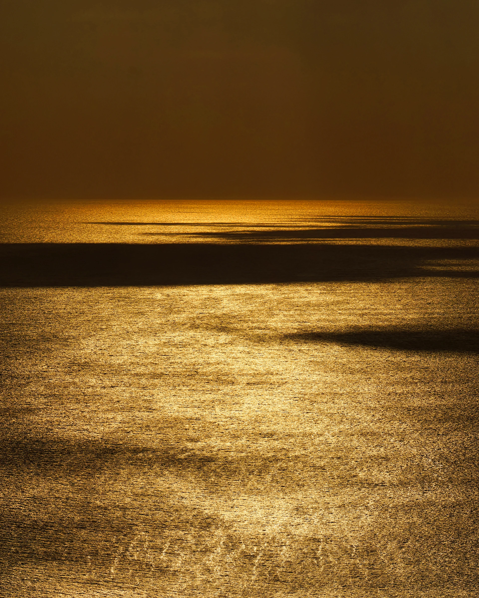 a large body of water with a boat in the distance