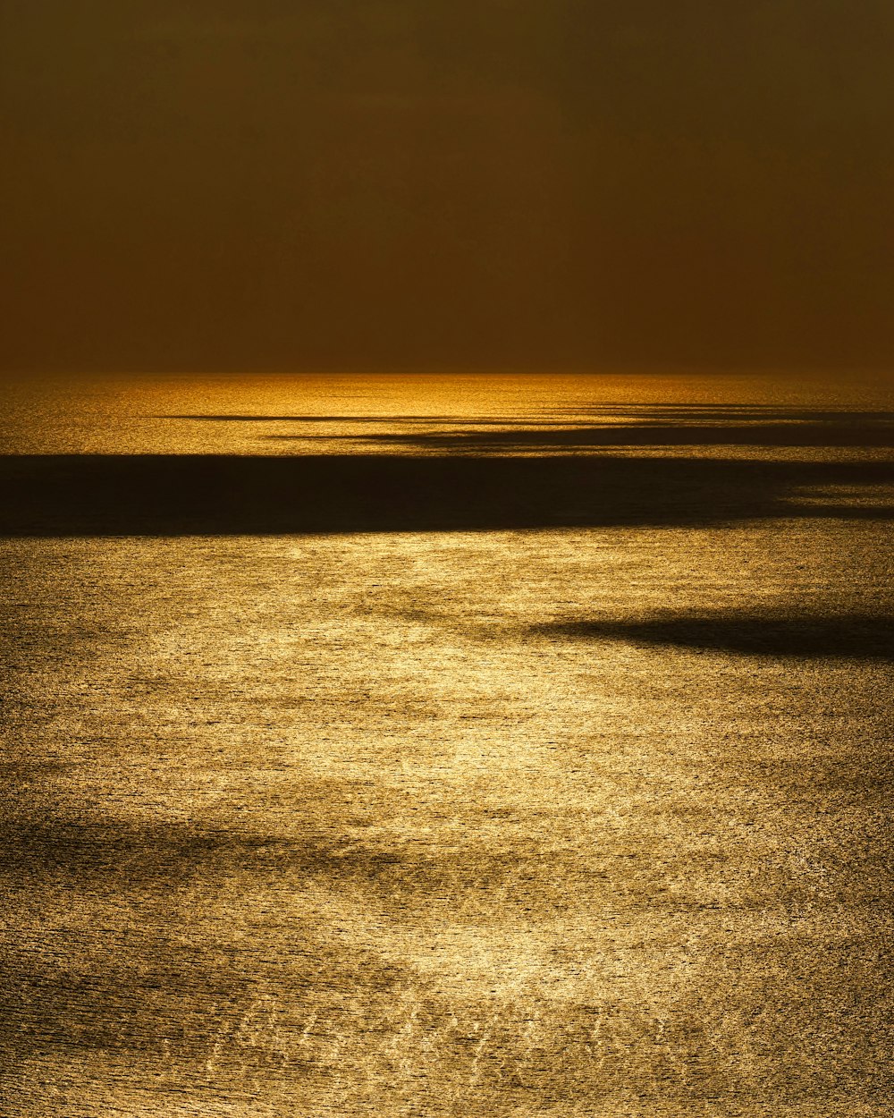 a large body of water with a boat in the distance