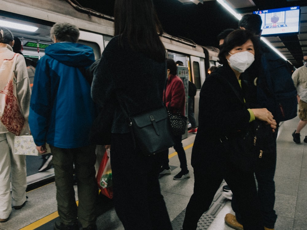 a group of people standing on a subway platform