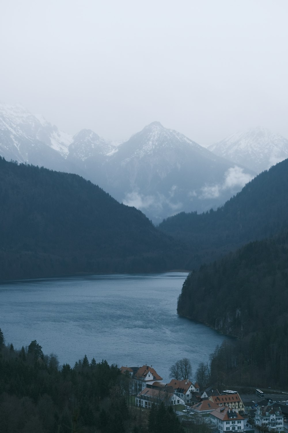 a lake surrounded by mountains in the middle of a forest