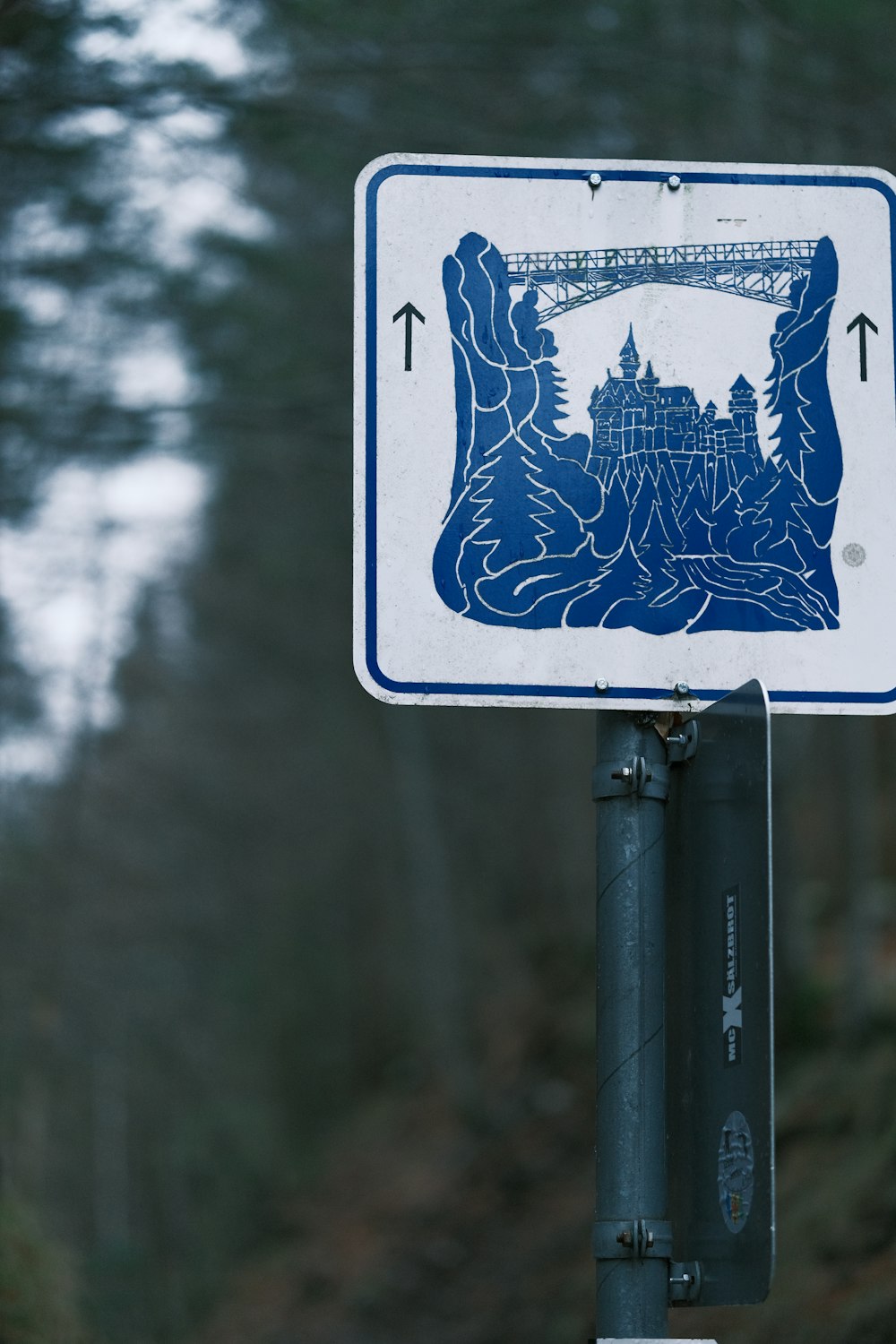 a blue and white sign on a metal pole