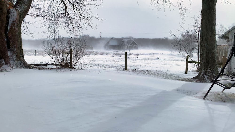 a snow covered field with a house in the background