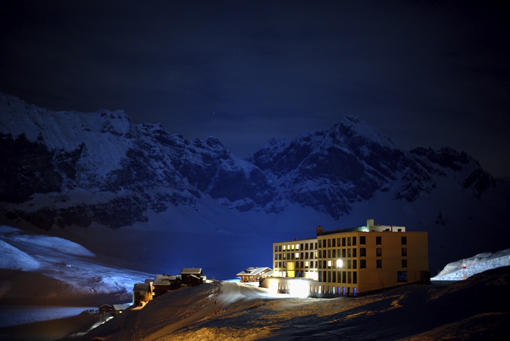 a building is lit up at night in the mountains