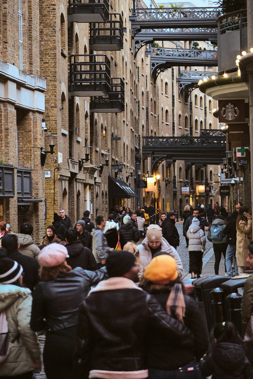 a crowd of people walking down a street next to tall buildings