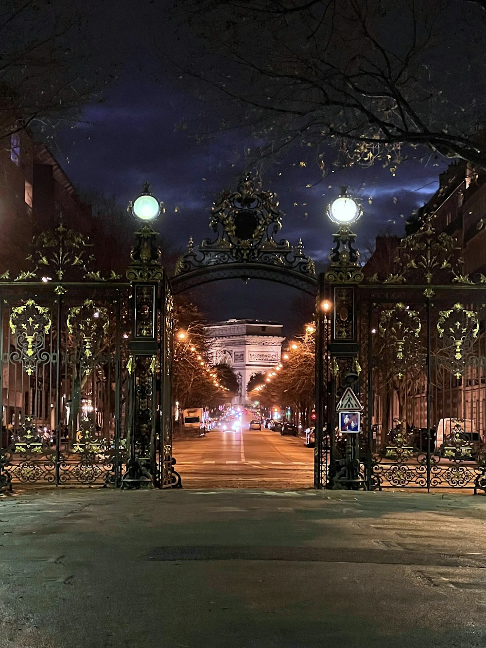 a night time view of a city street with a gate