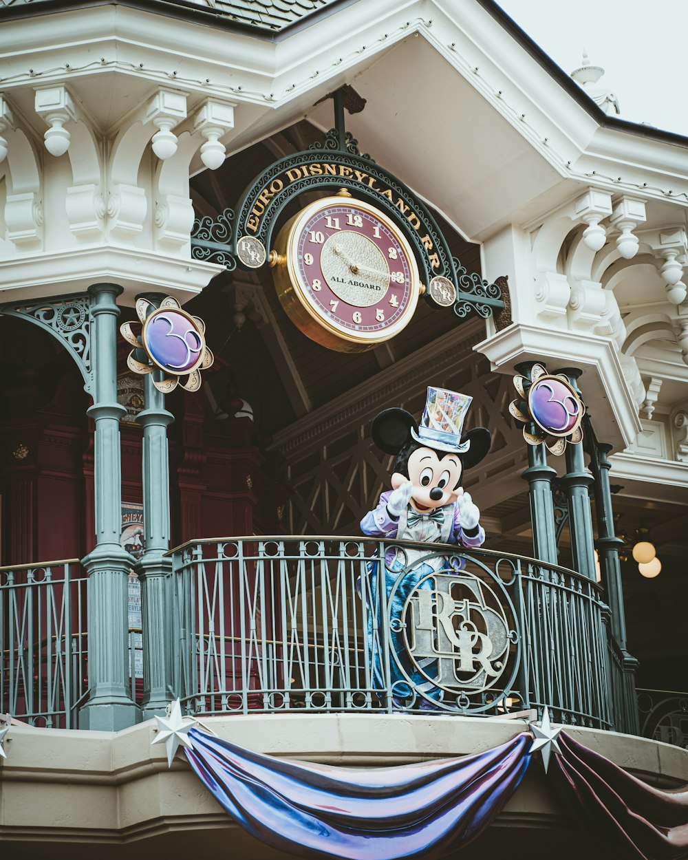 a mickey mouse clock on top of a building