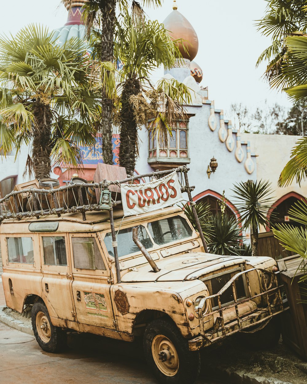 a rusted out vehicle parked in front of a building