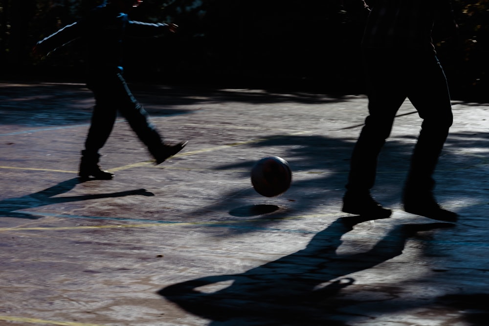 Zwei Personen spielen mit einem Ball im Dunkeln