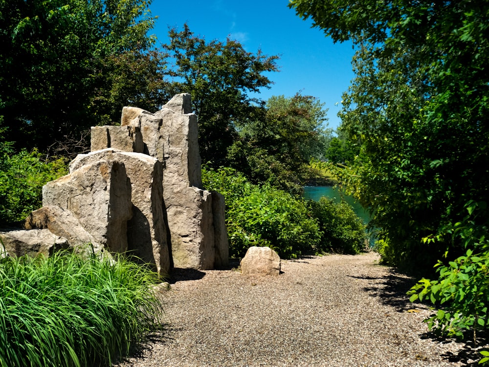 a stone structure sitting in the middle of a lush green forest