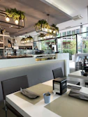 Chic café scene showcasing branded packaging on marble tables with greenery accents.