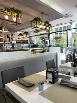 A bustling café interior showcasing elegant table settings and ambient lighting.