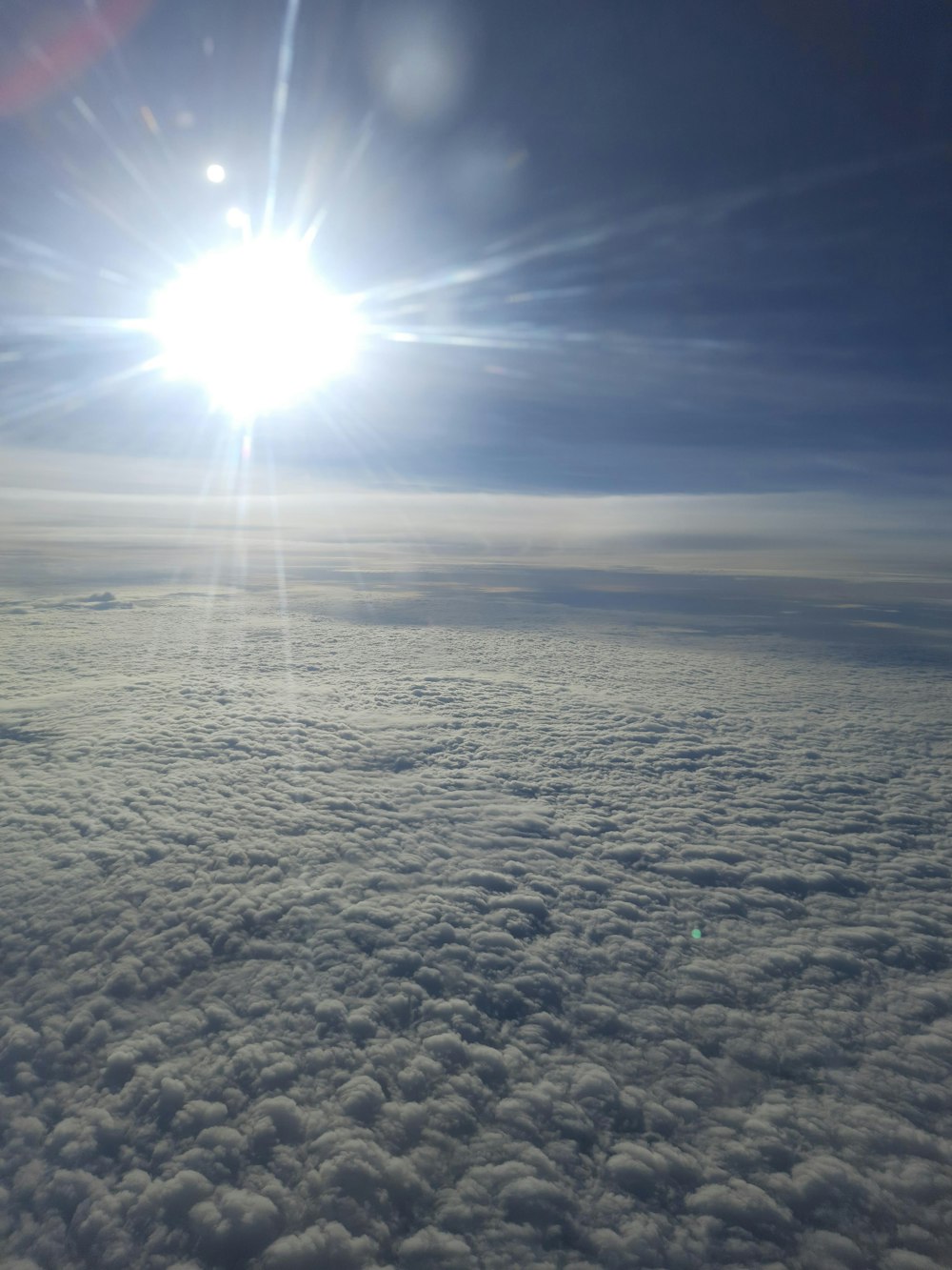 the sun is shining above the clouds in the sky