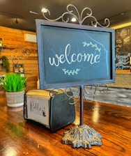 A cozy corner with a handwritten 'welcome' sign and a cup of coffee steaming beside it.