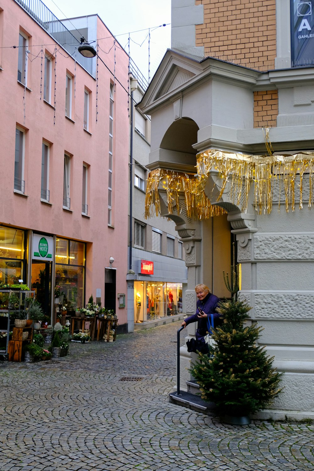 a man is decorating a christmas tree in a city