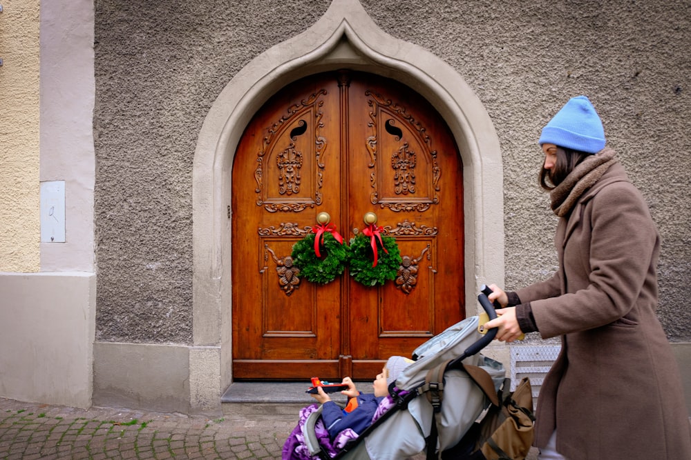 a man pushing a stroller in front of a wooden door
