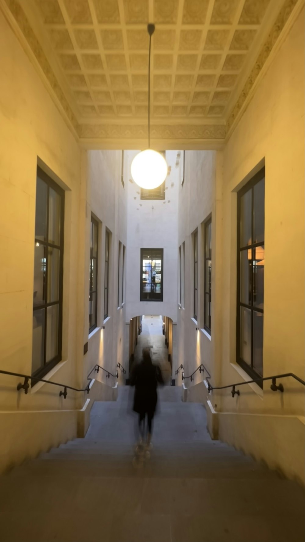 a person walking down a hallway with a light on