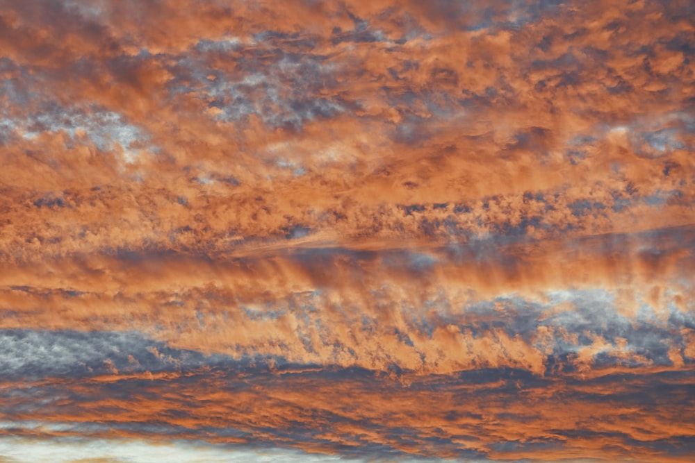 a plane is flying in the sky at sunset