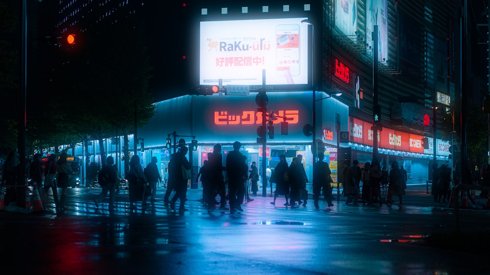 a group of people standing on a street at night