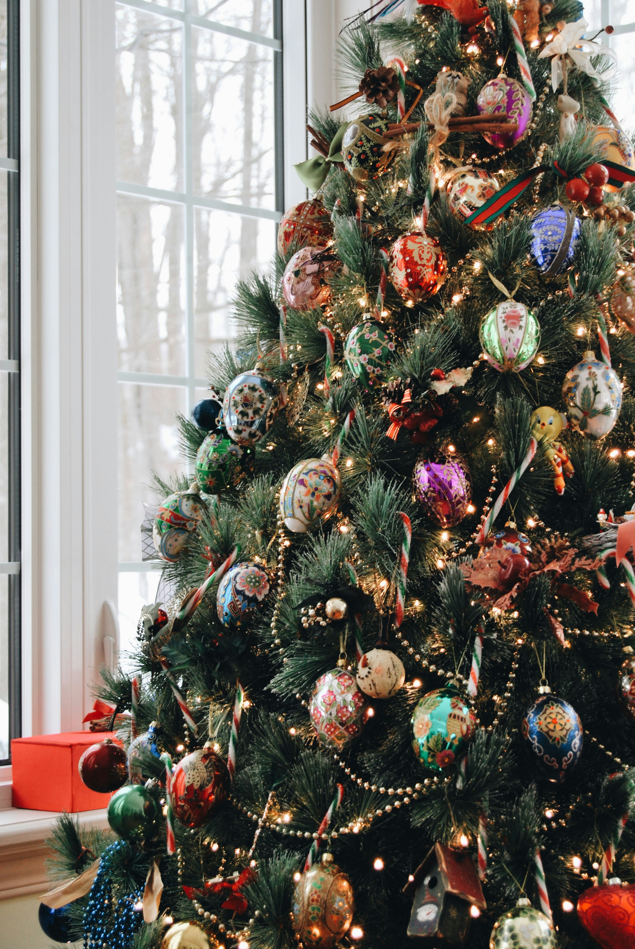 a decorated christmas tree in front of a window