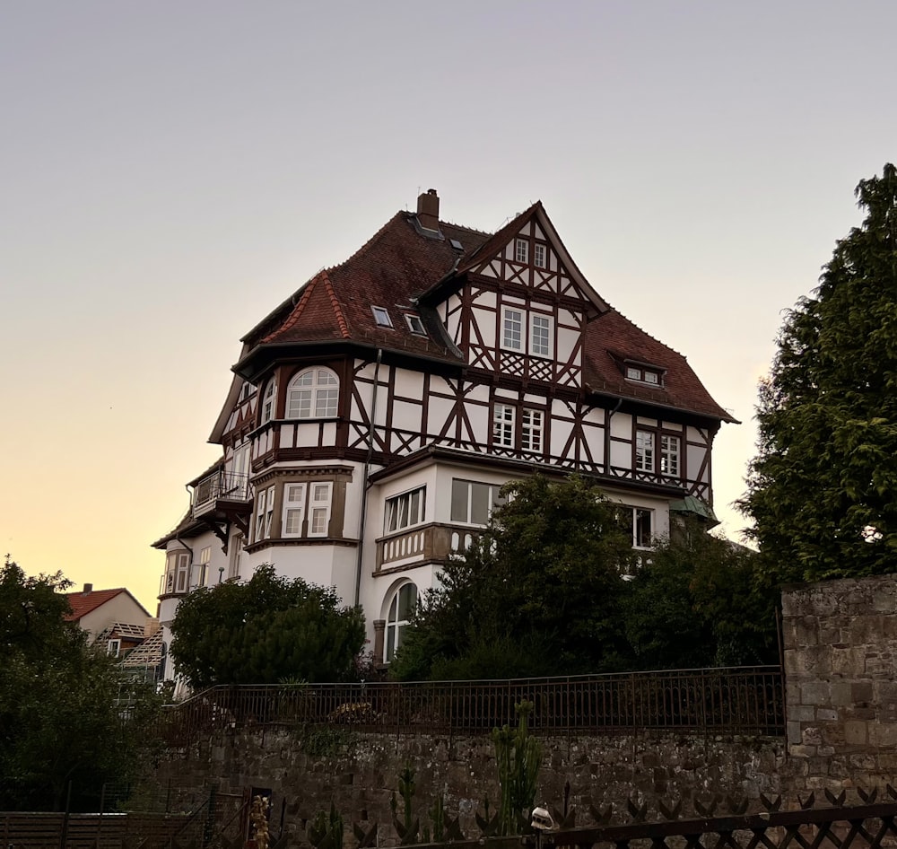 a large white and brown house sitting on top of a hill