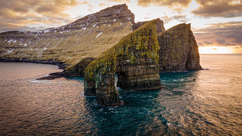 a large rock formation in the middle of a body of water