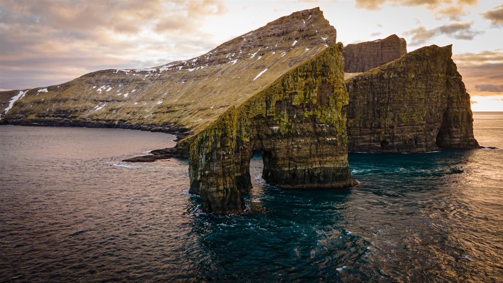 a large rock formation in the middle of a body of water