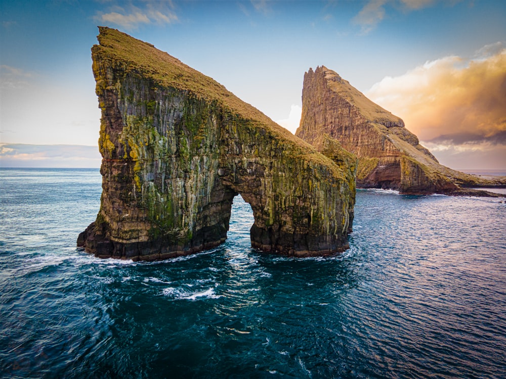 a large rock formation in the middle of the ocean