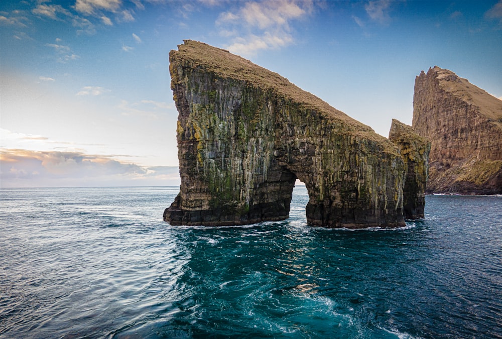 a large rock formation in the middle of the ocean