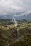 a view of a lush green valley with mountains in the background